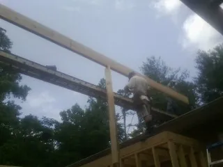 Carpenter setting a ridge beam over a new addition frame — Ice Dam Removal by Roofing Brothers in Dell Rapids