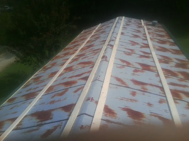 Rusted metal roof panels with new wood purlins before replacement — Storm Damage Roof Repair in Dell Rapids by Roofing Brothers