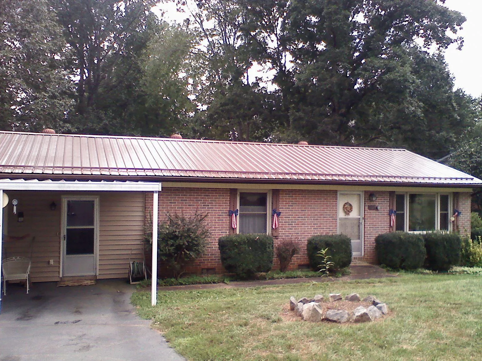 Bronze metal roof and carport on a brick ranch home — Roof Repair work by our crew in Dell Rapids